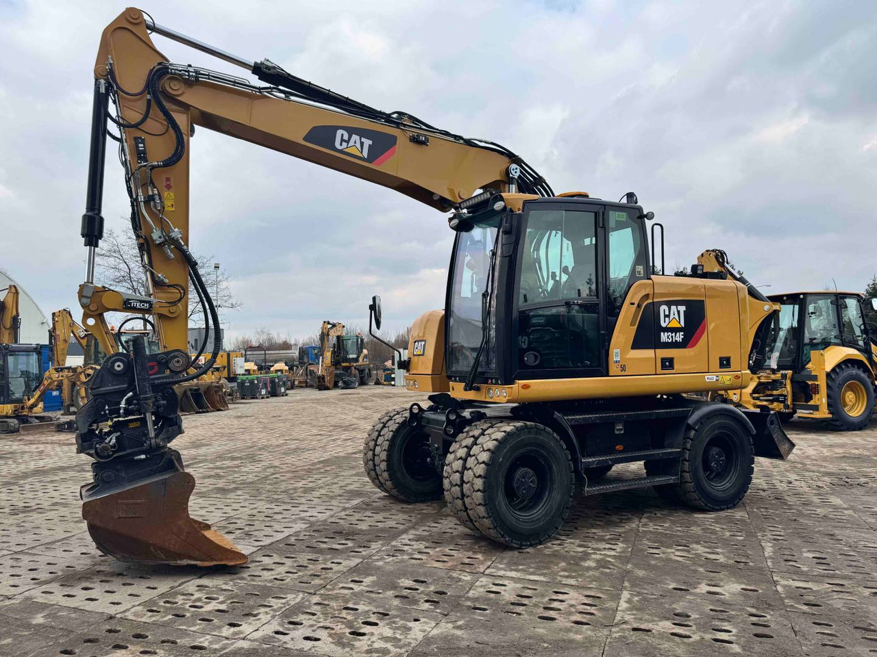 CAT M314F - حفارة دولاب: صورة 1 CAT M314F - حفارة دولاب: صورة 1