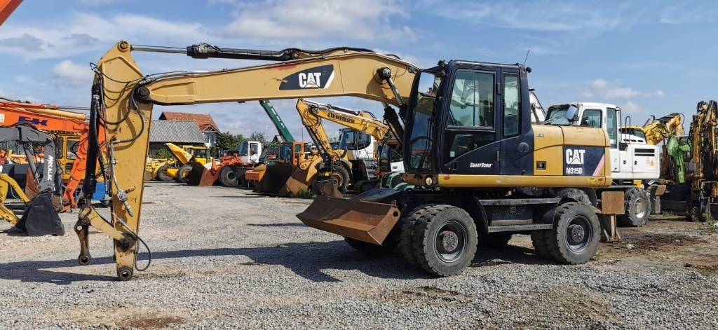 CAT M 315 D - حفارة دولاب: صورة 1 CAT M 315 D - حفارة دولاب: صورة 1